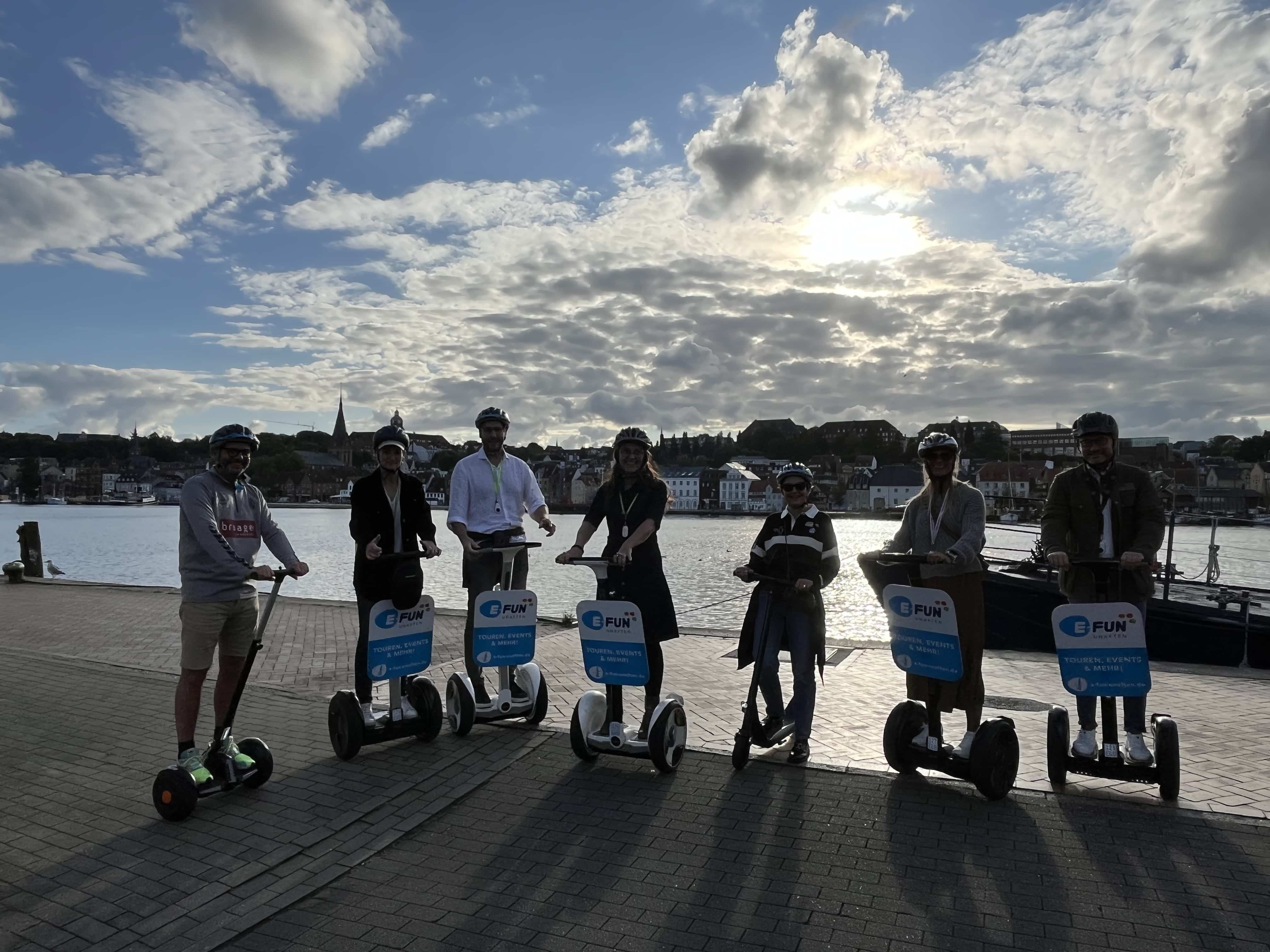 Segway Tour in Flensburg entlang der Förde mit Blick auf Wasser, Stadt und historische Gebäude.